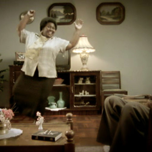 Woman dancing in living room in front of guest